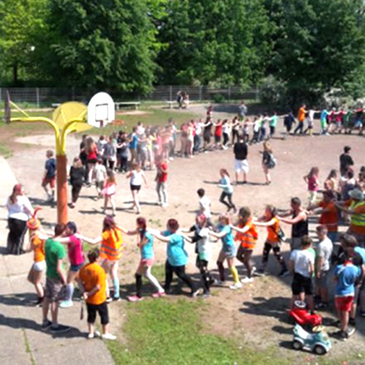 Schulkinder bei großer gemeinschaflicher Aktion auf dem Schulhof | Copyright: Diakonieverein Burghof e. V.