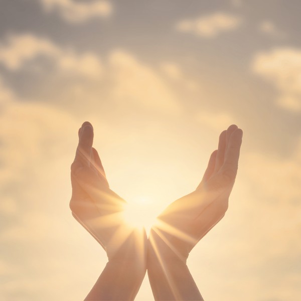 Hände in den Himmel gestreckt, umschließen die Sonne